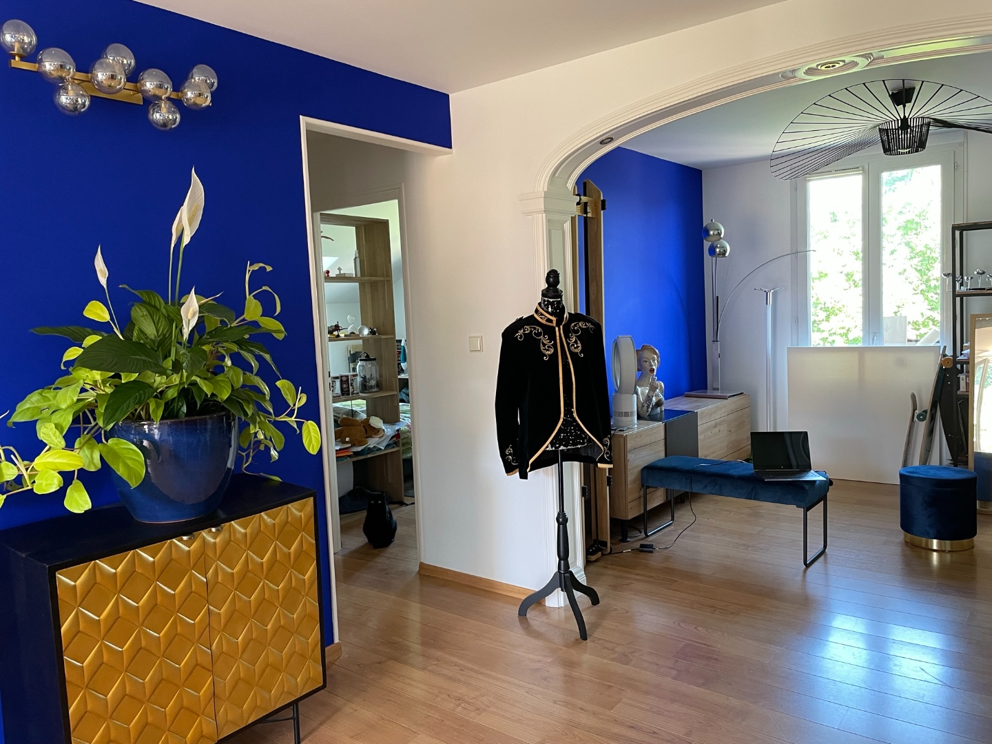 Entrée-galerie : mur bleu Klein, buffet doré, arche et suspension design